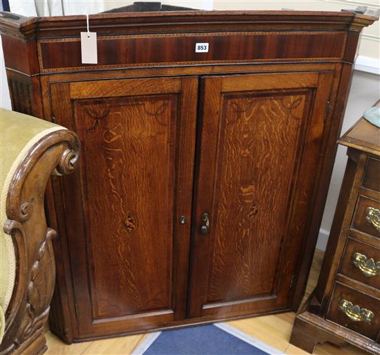 An early 19th century mahogany and oak corner cupboard, W.101cm